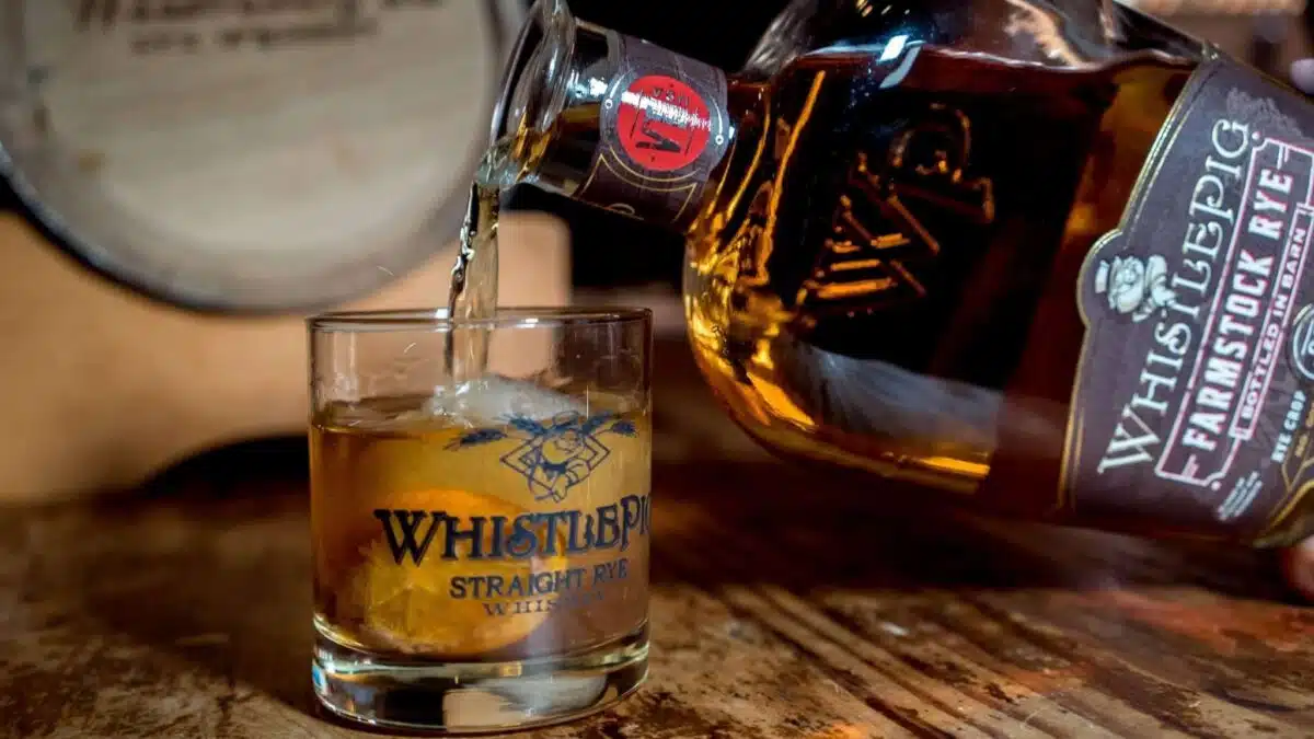 Whiskey poured into a glass beside its bottle